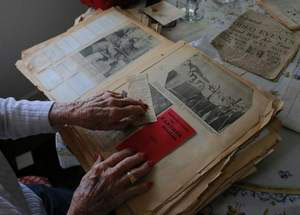 Dorothy Wallace, shown in her home, looks over albums of newspaper clips she has kept that cover the years between World War I and World War II. Wallace will be among members of an oral history program Dec. 13 at the National Steinbeck Center. The program also includes Latinos in Chinatown, a continuation of the Chinatown project featured at the Steinbeck Center each spring the past three years. The California State University, Monterey Bay Oral History and Community Memory service learning class has been working on the project. / Travis Geske/The Salinas Californian