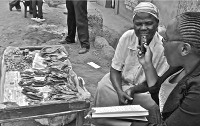 Kibera Citizen Archivist Agnes (Chelsea) Cheboo Ruto conducts an interview with a fish seller. Photo: Raymond Gathee.