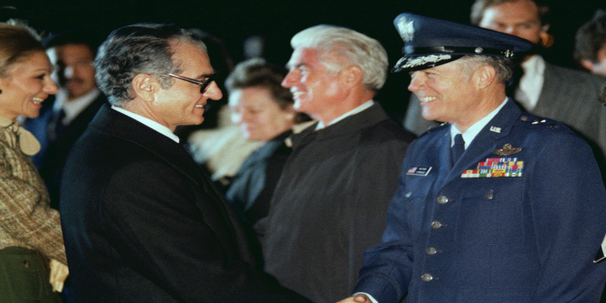 Image Credit: Mohammed Reza Pahlavi, Shah of Iran, shakes hands with a US Air Force general officer prior to his departure from the United States (Wikipedia Public Domain).